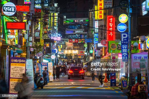 seul strade affollate della vita notturna di sinchon segni neon corea del sud - seoul foto e immagini stock
