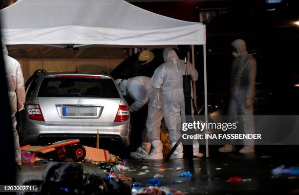 Police officers investigate the car of the man who drove into a carnival procession on February 24, 2020 in Volkmarsen near Kassel, central Germany....