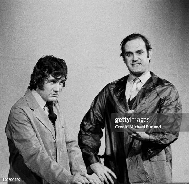 Michael Palin and John Cleese of comedy team Monty Python perform the 'Dead Parrot Sketch' on stage in London, 1974.