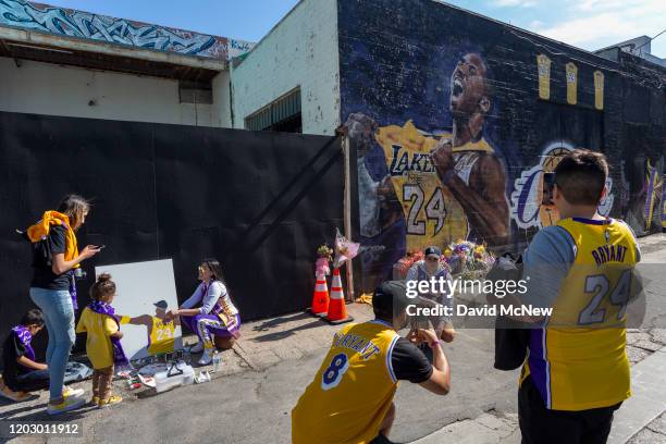 Fans gather near a mural for former Los Angeles Lakers basketball star Kobe Bryant during the official memorial ceremony for Kobe and his daughter,...