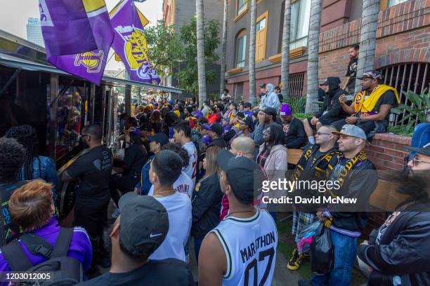 Fans crowd around a truck on a downtown street to see the official memorial ceremony for former Los Angeles Lakers basketball star Kobe Bryant and...