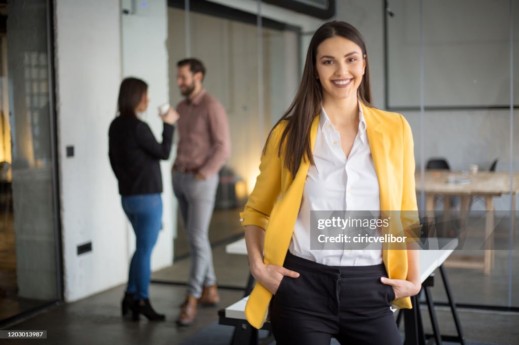 Fashionable businesswoman standing and looking at camera
