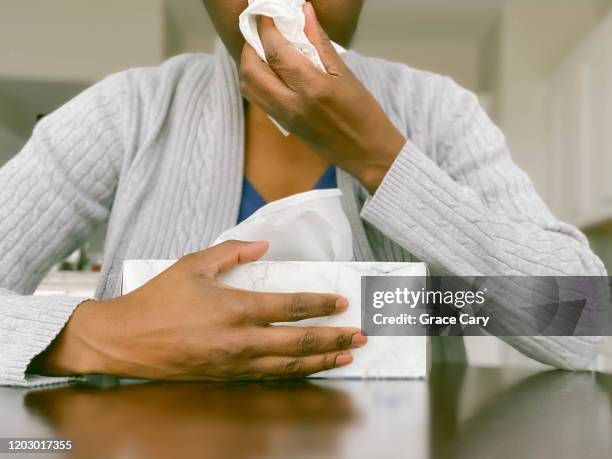 african-american woman with box of tissue blows nose - tissue box stock-fotos und bilder