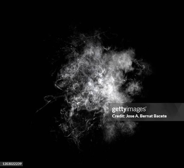 explosion by an impact of a cloud of particles of powder of white color on a black background. - steam black background stock pictures, royalty-free photos & images