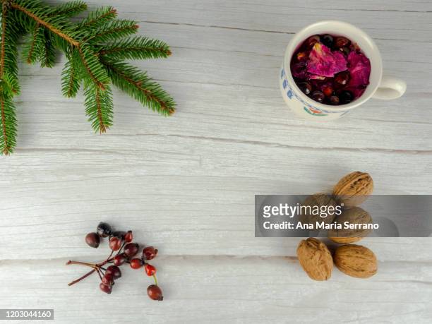 a cup of hot infusion of medicinal herbs with rose hips, hawthorn and rose petals and walnuts - hot hips 個照片及圖片檔