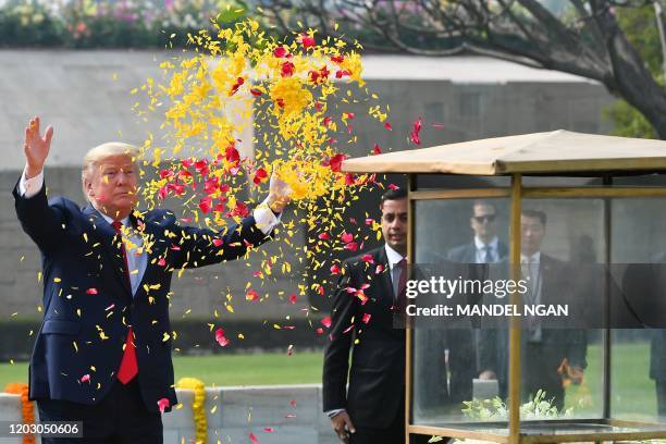 President Donald Trump sprays flower petals to pay tribute at Raj Ghat, the memorial for Indian independence icon Mahatma Gandhi, in New Delhi on...