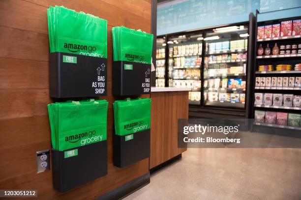 Reusable grocery bags sit in bins during a tour of a new Amazon Go store in the Capitol Hill neighborhood of Seattle, Washington, U.S., on Monday,...