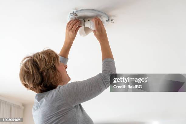 woman bulb replacement at home - led stock pictures, royalty-free photos & images