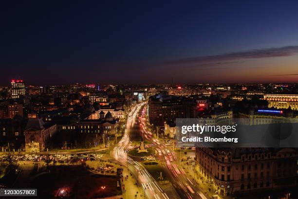 Light trails from passing vehicles illuminate a roundabout on Boulevard Nicolae Balcescu at night in Bucharest, Romania, on Thursday, Feb. 13, 2020....