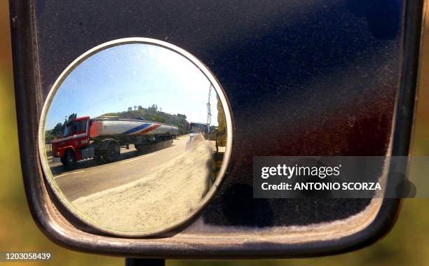 Non-member truck of the national strike of truck drives is reflected in the mirror of another participant of the strike at the border of the highway...