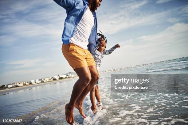 jumping right into summer - beach family jumping stock pictures, royalty-free photos & images