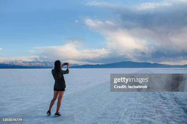 frau fotografiert in der salzwüste in argentinien - saltar stock-fotos und bilder