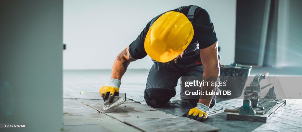 Master installer laying tile