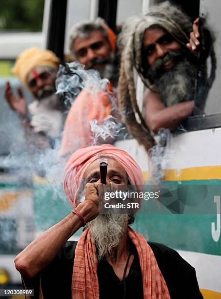 Sadhu - holy man - enjoys smoking a chillum while waiting for departure for the Amarnath cave shrine, on the National Highway in Jammu on June 28,...