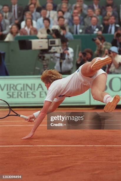 German tennis player Boris Becker dives to reach the ball in his match against Sweden's Mats Wilander here 05 june 1987 at Roland Garros stadium...
