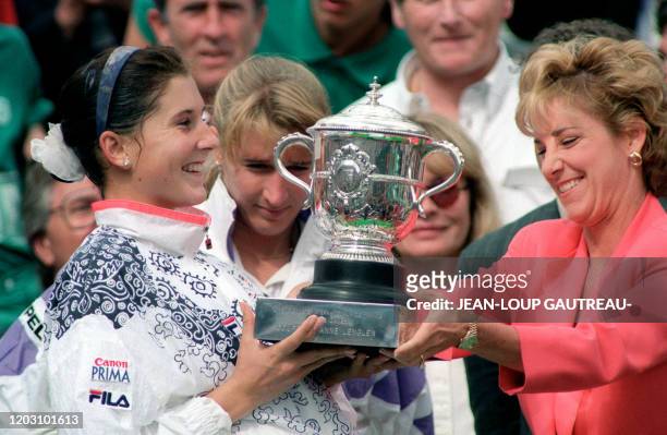 Yugoslavian tennis player Monica Seles receives the Winner's trophy from American former tennis star Chris Evert here 06 june 1992 at Roland Garros...