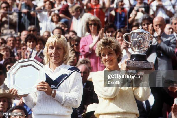 American tennis player Chris Evert-Lloyd and compatriot Martina Navratilova hold their respective trophies here 8 june 1985 at the end of the Women's...