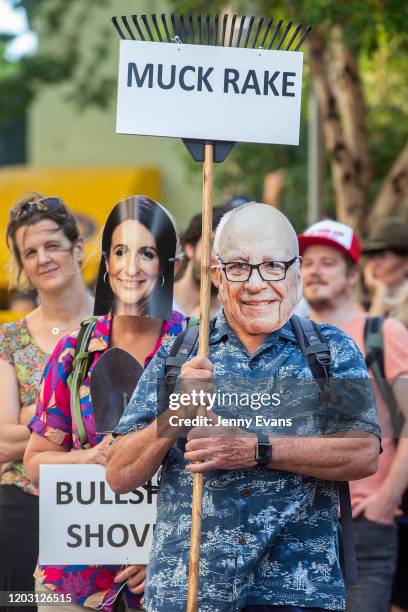 Protester with a Rupert Murdoch mask holds a placard at the offices of News Corp Australia in Surry hills on January 31, 2020 in Sydney, Australia....