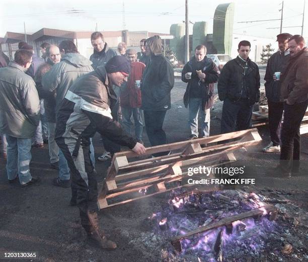 Des grévistes se réchauffent près d'un feu, le 23 décembre, à un piquet de grève, au huitième jour du mouvement des conducteurs de la compagnie de...