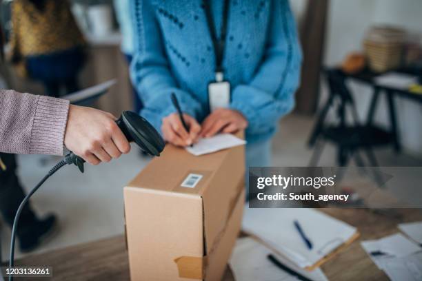 woman using bar code reader for arranging customers orders for drop shipping - post office stock pictures, royalty-free photos & images