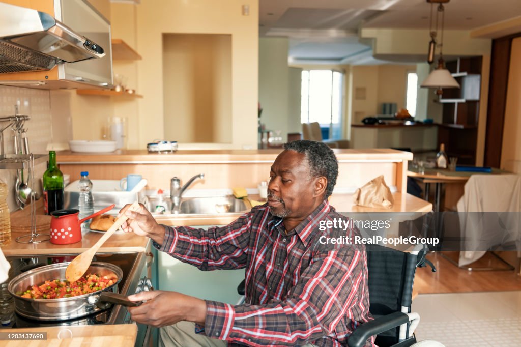 Senior Afro-American in Wheelchairs is Preparing a Lunch at Home