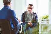 Mature man talking with psychotherapist in his office