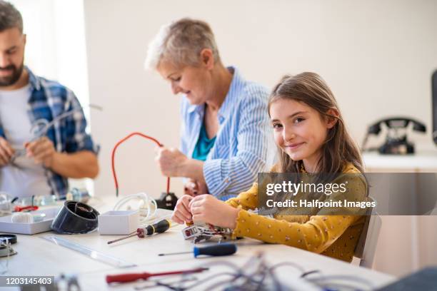 a group of people repairing household equipment in community center. - repairing clothes stock pictures, royalty-free photos & images
