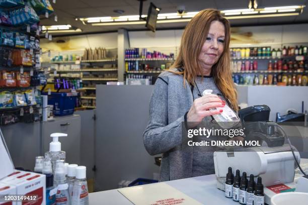 Woman sells a hand sanitizing gel in a pharmacy in Amsterdam, on February 25, 2020. - Since the number of coronavirus infections in Europe is...