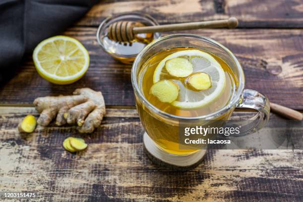 a cup of lemon ginger tea with honey - tee stock-fotos und bilder