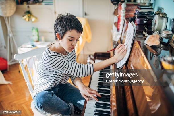 joven pianista componiendo música en su habitación en casa - pianista fotografías e imágenes de stock