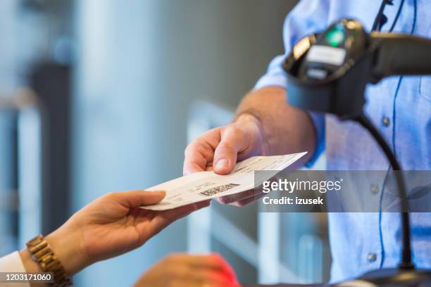 operador de aerolíneas escaneando billete de avión - taquilla lugar de comercio fotografías e imágenes de stock