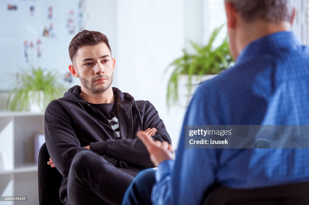 Serious university student listening to therapist