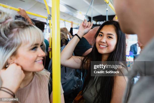 friends riding the bus - grab handle stock pictures, royalty-free photos & images