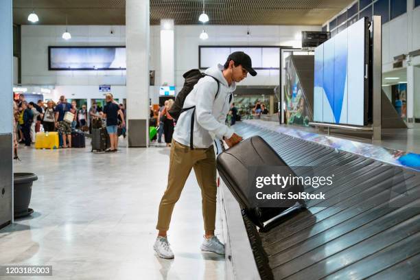 picking up luggage - baggage claim stock pictures, royalty-free photos & images