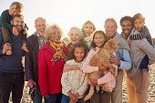 Portrait Of Multi-Generation Family Group With Dog On Winter Beach Vacation