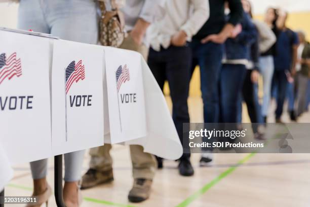 low-winkel-ansicht der menschen, die zur abstimmung aufgereiht sind - us präsidentschaftswahl stock-fotos und bilder