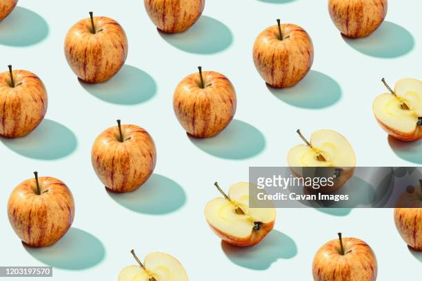 pattern background of red apples on cyan background. vibrant colorful pattern - apple pattern stock-fotos und bilder