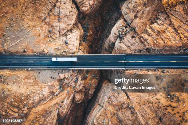 a slot canyon with a crossing road in arizona - suv berg stock-fotos und bilder