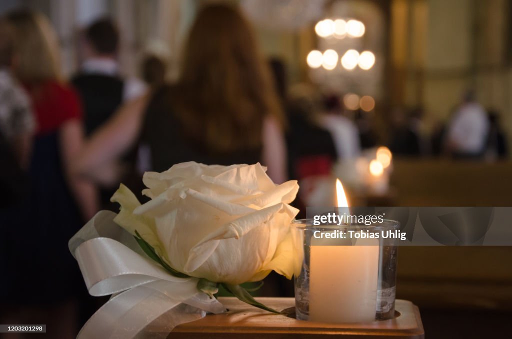 White rose and candle in a church