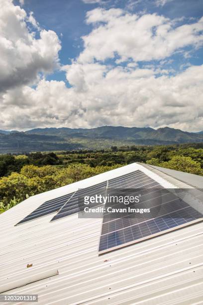 solar panels await installation on rooftop of rural building. - solar panel city stock-fotos und bilder