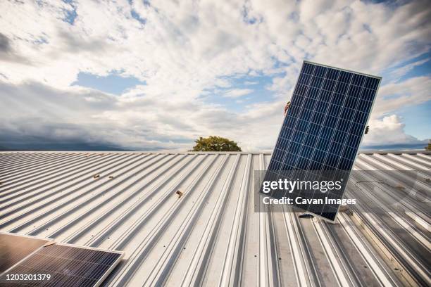 low angle of hidden person carrying solar panel on roof. - lift roof bildbanksfoton och bilder