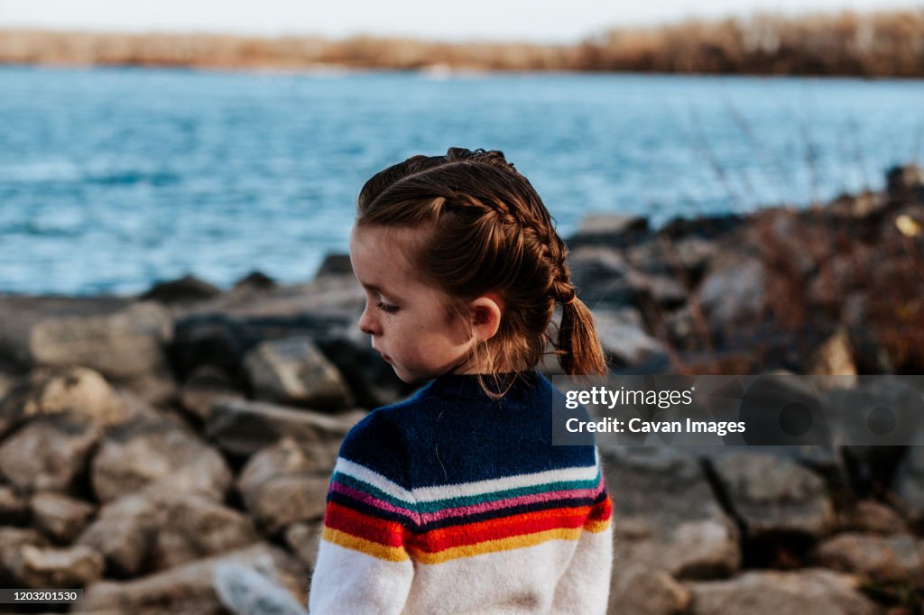 Girl Looking Over Rocks Portrait Of Young Girl Looking Away On Rocks At A Lake High-Res Stock ...