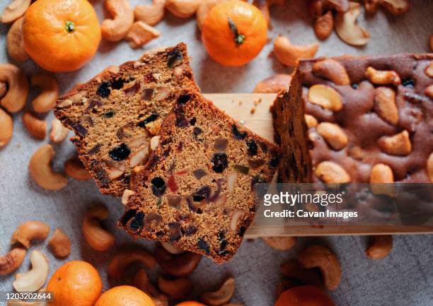 sliced fruit cake with cashew nuts and oranges - fruitcake stock-fotos und bilder