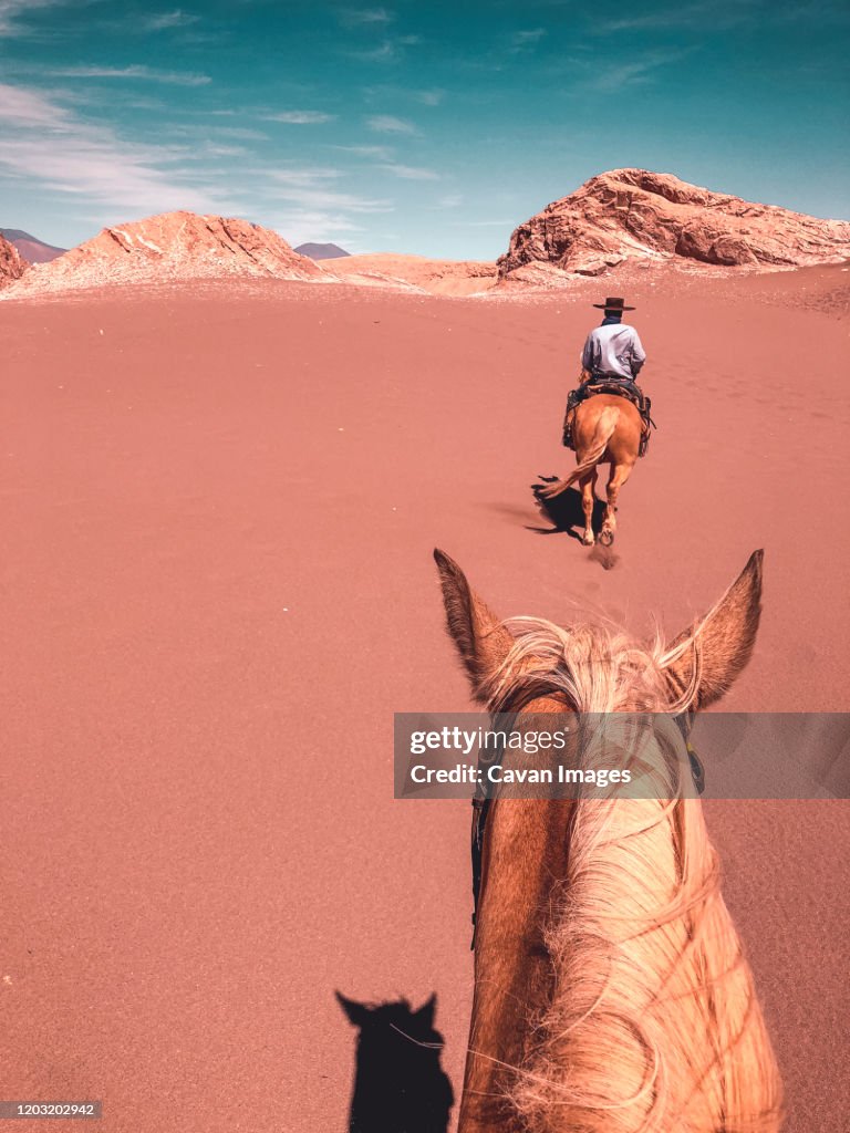 First person view of a young male horseback riding through Desert