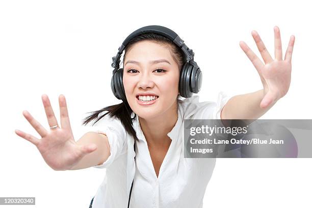 young woman dancing while listening to headphones - 手を伸ばす 女性 ストックフォトと画像