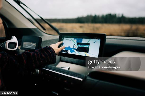 young boys hand pointing at a gps sat nav map in an electric car - gps stock-fotos und bilder