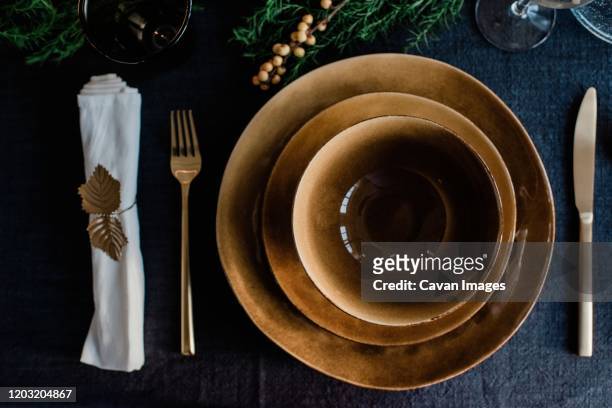 gold plates and bowls with gold cutlery on a decorated dinner table - gold meets golden fotografías e imágenes de stock