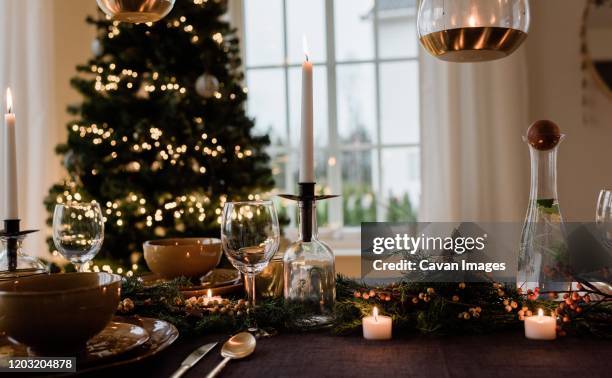 tall candle on a festively decorated dinner table at christmas - room after party stock pictures, royalty-free photos & images