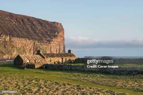 burnmouth bothy stone shelter in below dramatic sea cliffs at rackwick bay, hoy, orkney, scotland - hoy imagens e fotografias de stock