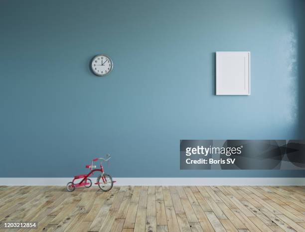 empty room with kid's tricycle and clock on the wall - tricycle stock pictures, royalty-free photos & images